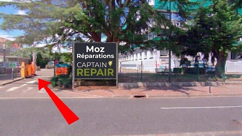 Entrée du parking MOZ Réparations vue depuis la rue de Clairefontaine — flèche rouge indiquant la barrière d'accès